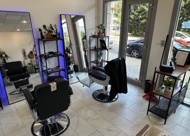 Modern interior of Újlipót Barber Shop in Budapest, Magyar, HU with sleek chairs and well-lit mirrors.