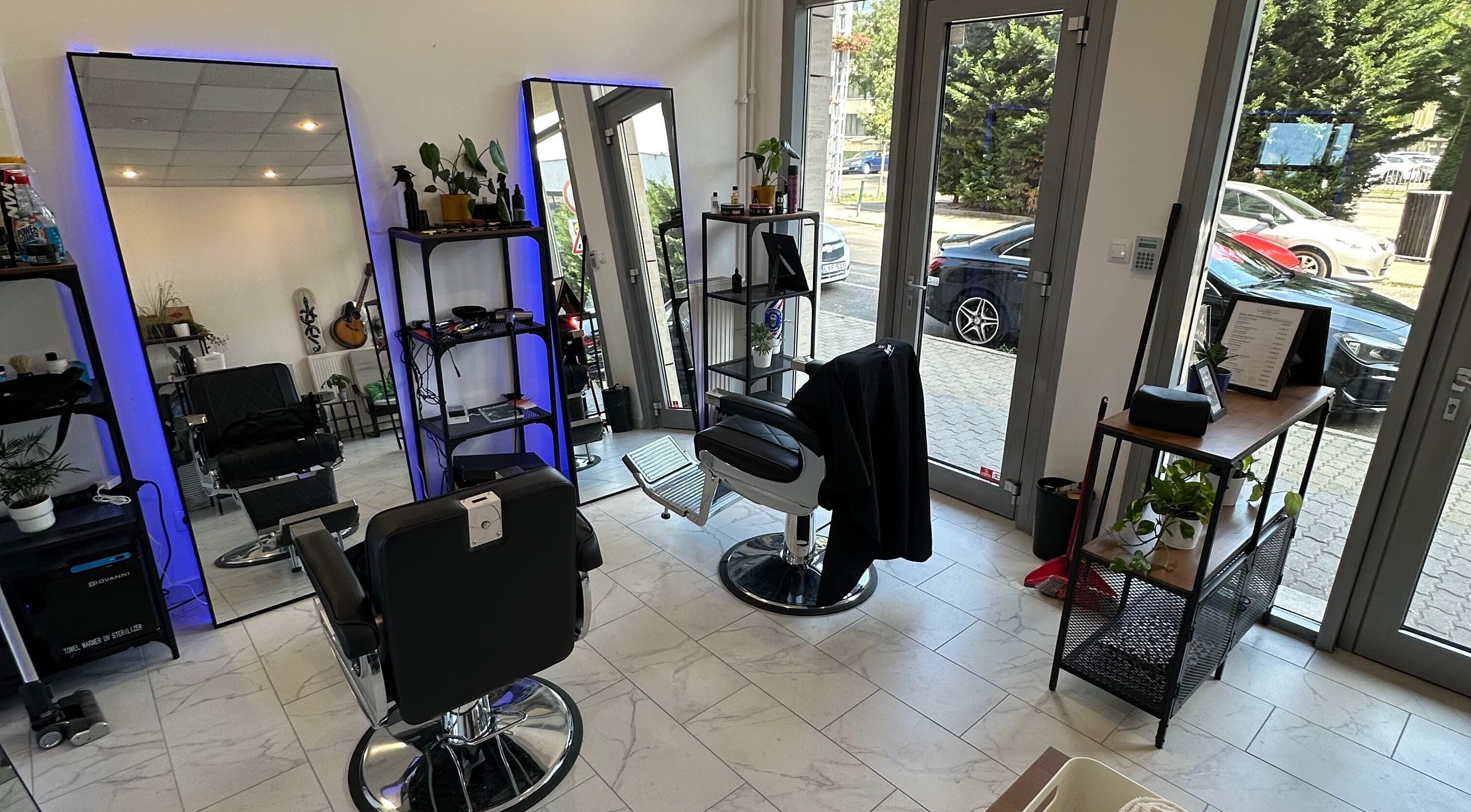 Modern interior of Újlipót Barber Shop in Budapest, Magyar, HU with sleek chairs and well-lit mirrors.