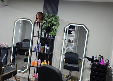 Interior de Jackeline’s hair en Calgary, Alberta, CA, con sillones y espejos elegantes.