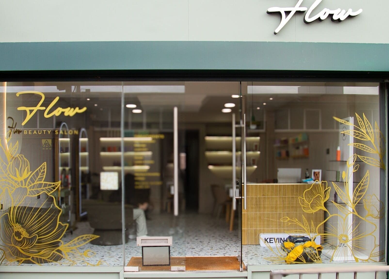 Front view of Flow, a chic beauty salon in London, England, GB, featuring modern floral designs on glass.