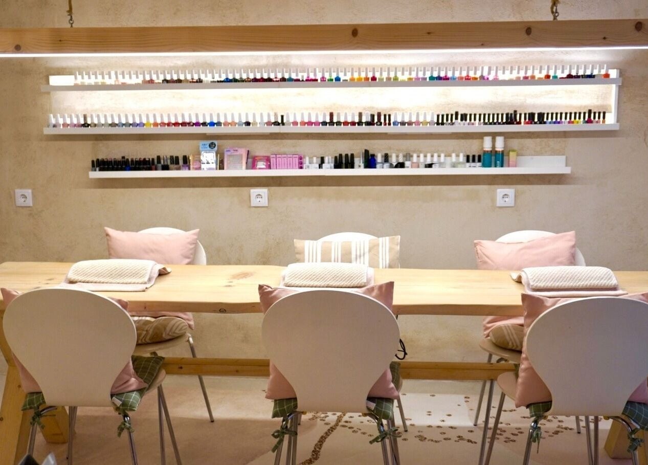 Cozy nail care setup at Sant Sever Massage, Barcelona, Catalunya, ES, featuring pastel chairs and polish display.