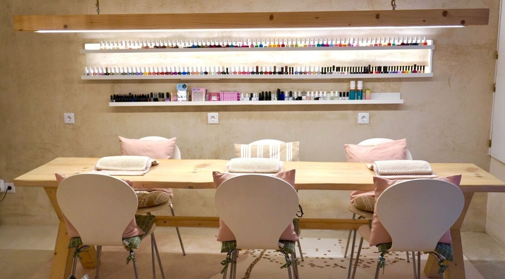 Cozy nail care setup at Sant Sever Massage, Barcelona, Catalunya, ES, featuring pastel chairs and polish display.