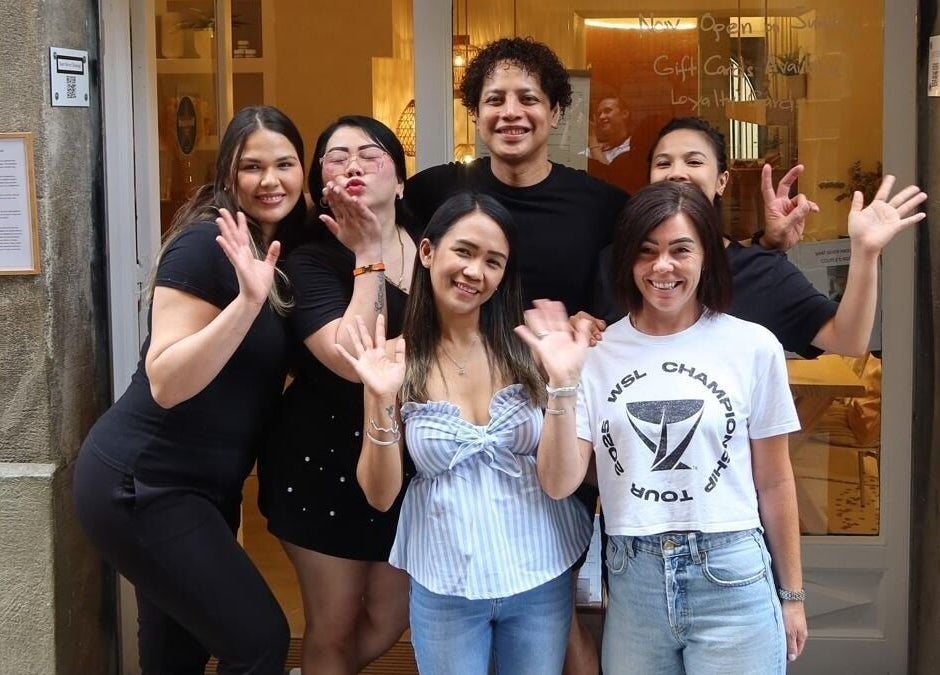 Team of Sant Sever Massage outside venue in Barcelona, Catalunya, ES, smiling and waving joyfully.