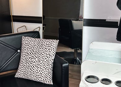 Eleventh Hour Hair in Gainesville, Georgia showcases modern black salon chair with a chic patterned pillow.