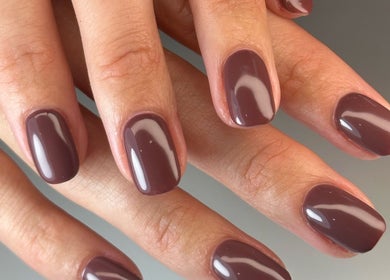 Close-up of shiny burgundy manicured nails done at Luna Nails in Bradford, England, GB.