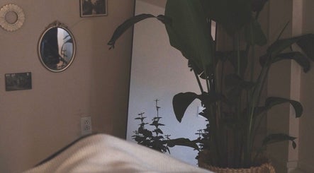 Peaceful room at Rafaëlle Rotunno Massothérapie, Pointe-Claire, Québec, CA with plants and a mirror.