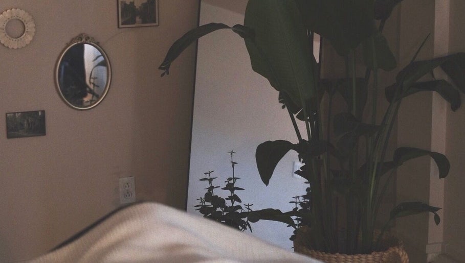 Relaxing corner at Rafaëlle Rotunno Massothérapie, Pointe-Claire, Québec, CA with mirror and lush plant decor.