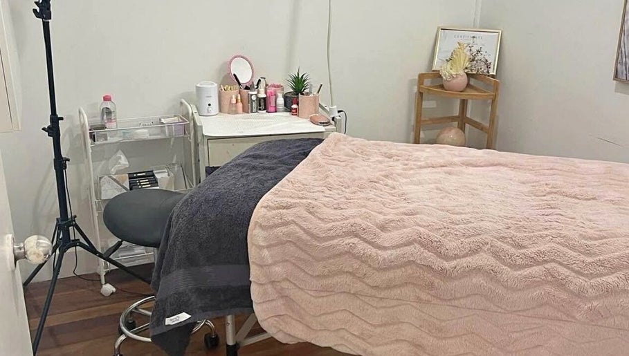 Lash Muse serene treatment room in Broadbeach, Queensland, AU with a cozy bed and soft pink decor.
