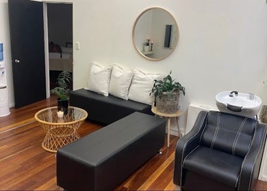 Relaxing lounge area at Lash Muse, Broadbeach, Queensland, AU with sleek seating and chic decor.