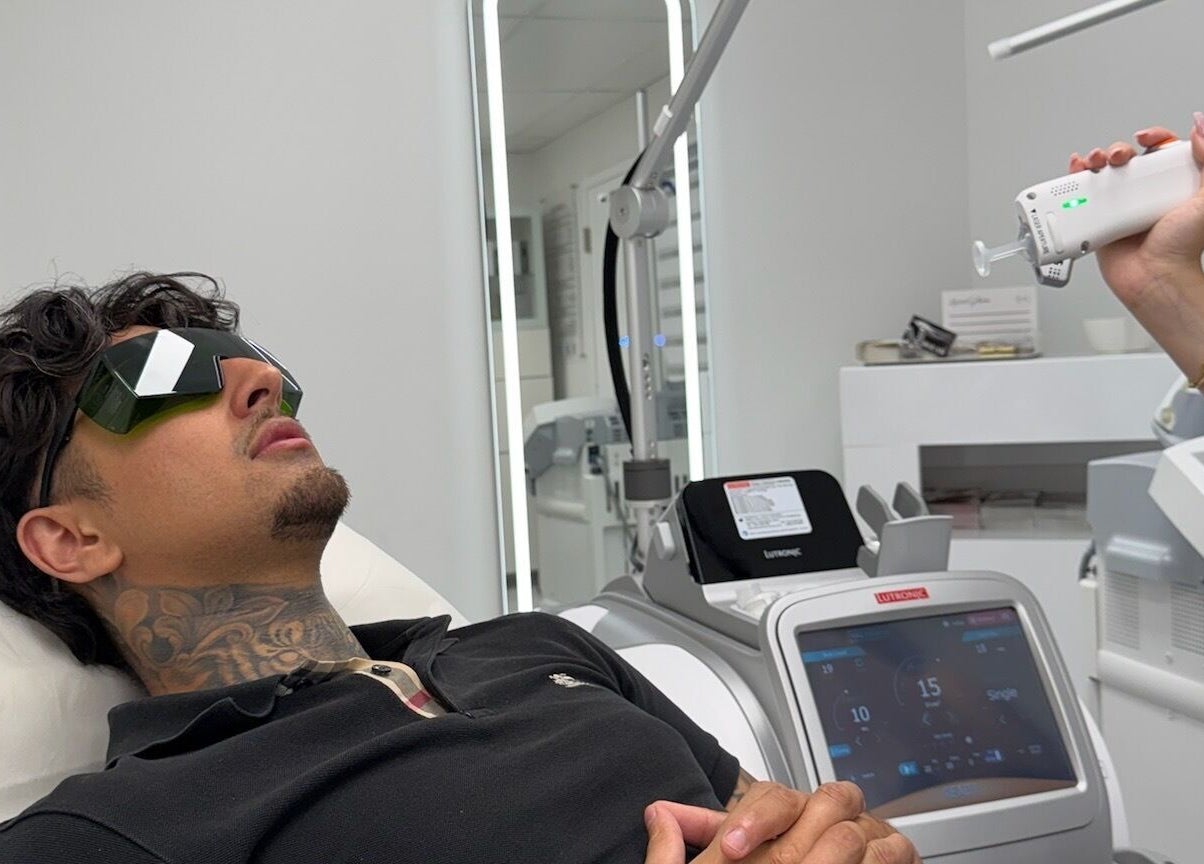 Man receiving laser treatment at LaserGlam, Laval, Québec, CA, wearing protective glasses in modern clinic.