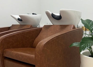 Luxury hair washing stations at VÉRAH in Yeppoon, Queensland, AU, with plush chairs and a sleek interior.
