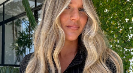 Woman with flowing blonde hair at VÉRAH, Yeppoon, Queensland, AU, showcasing natural beauty in lush setting.