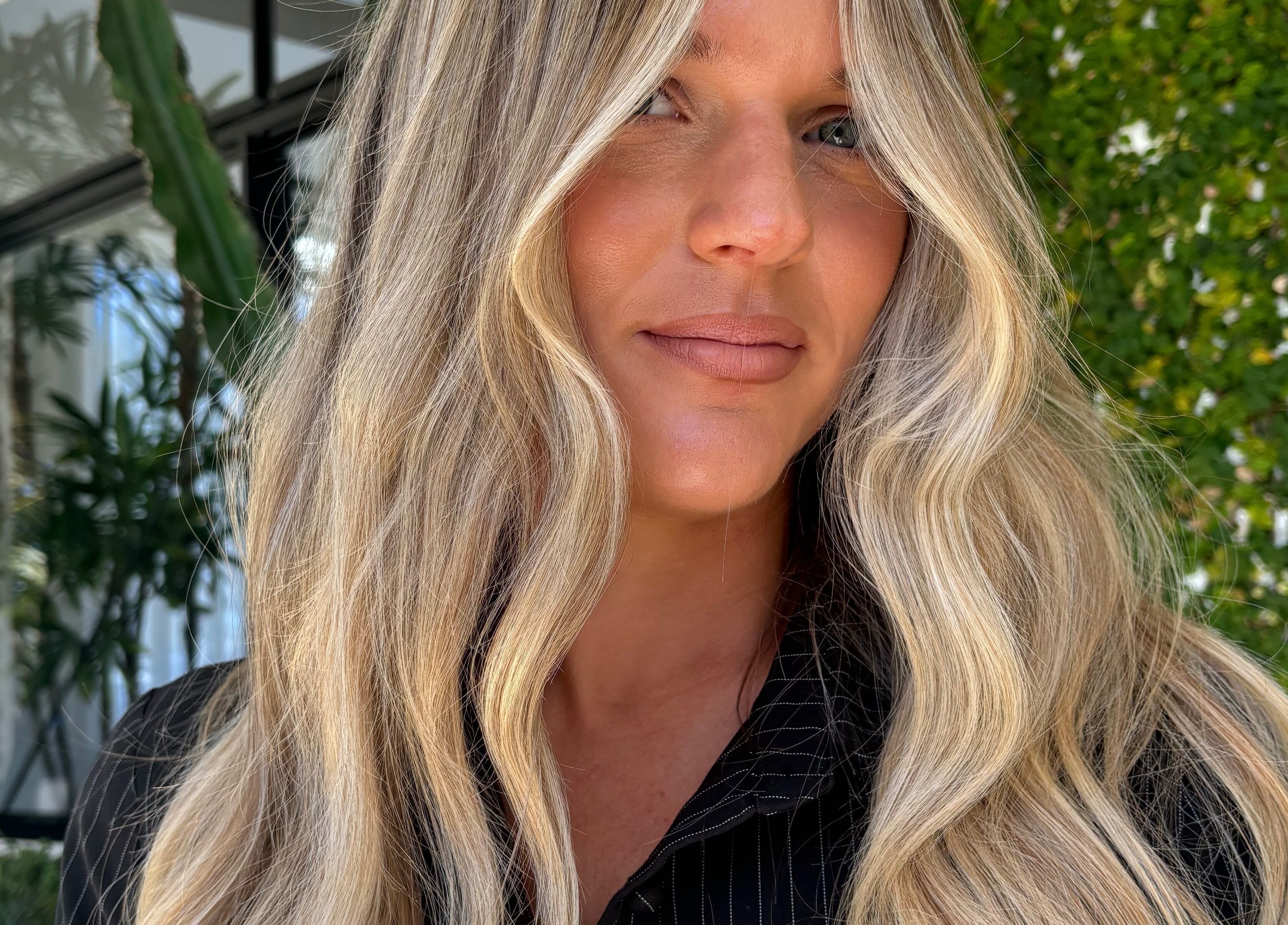 Woman with sunlit wavy hair at VÉRAH, Yeppoon, Queensland, AU for beauty and wellness.