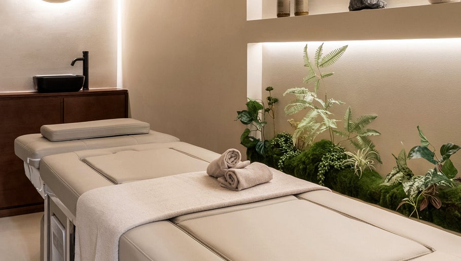 Luxurious spa bed at Gili Head Spa, New York, NY, with earthy decor creating a tranquil atmosphere.