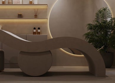 Modern curved lounge at Gili Head Spa, New York, New York, US, with ambient lighting and plant decor.