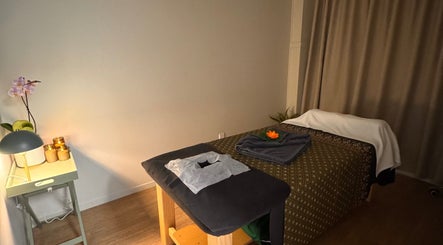 Serene massage room at Inlux Thai Massage & Spa, Pukekohe, Auckland, NZ with warm lighting and a cozy table.