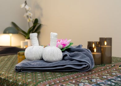 Relaxing massage setup at Inlux Thai Massage & Spa, Pukekohe, Auckland, NZ with herbal compress and candles.