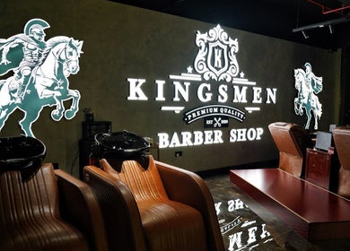 Sleek interior of Kingsmen Barbershop, Dubai, AE, featuring stylish chairs and illuminated signage.