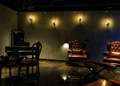 Luxurious waiting area at Kingsmen Barbershop, Dubai, UAE with leather chairs and elegant decor.