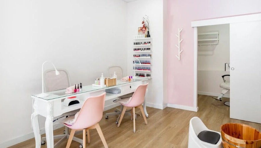 Interior elegante de Rose Nails and Beauty en Madrid, Comunidad De Madrid, ES con sillas rosas y mesa moderna.