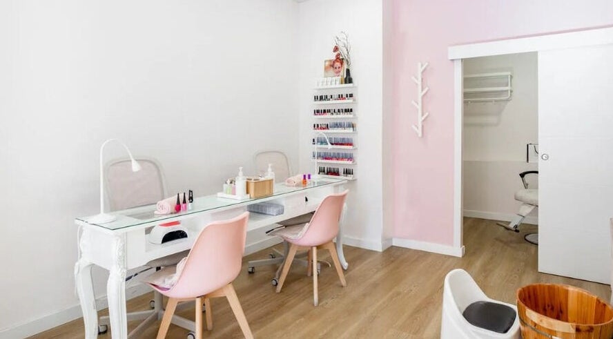 Interior elegante de Rose Nails and Beauty en Madrid, Comunidad De Madrid, ES con sillas rosas y mesa moderna.