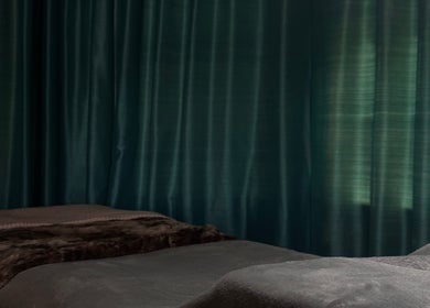 Relaxing treatment beds at Lashes By Esmé June, Higher Whitley, England, GB with elegant dark curtains.