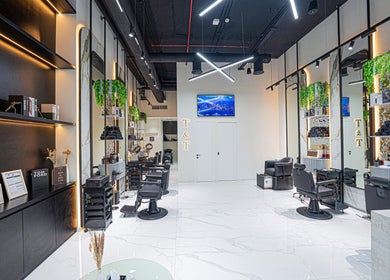 Interior view of Trim & Tame Men Saloon in Dubai, Dubai, AE, featuring stylish chairs and modern decor.