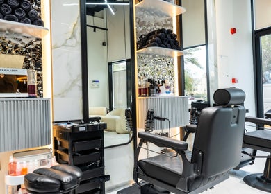 Interior of Trim & Tame Men Saloon, Dubai, Dubai, AE featuring modern barber chairs and sleek design.