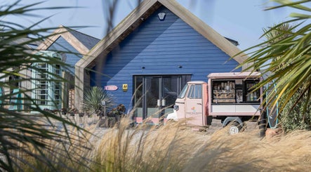 Relax at Three Mile Beach entrance with blue exterior and mobile coffee shop. Gwithian, England, GB.