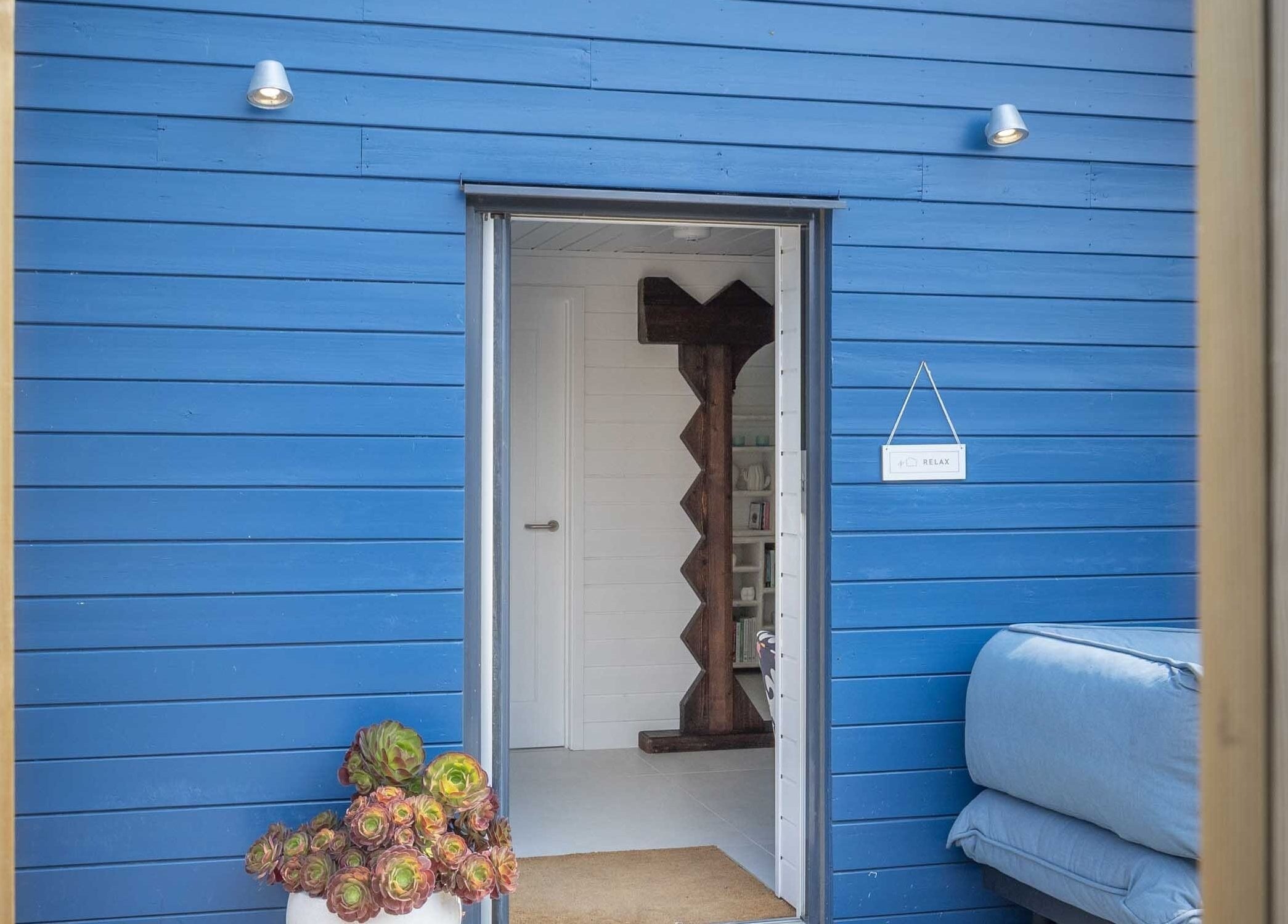 Relax at Three Mile Beach entrance with blue walls and flowers, Gwithian, England, GB.