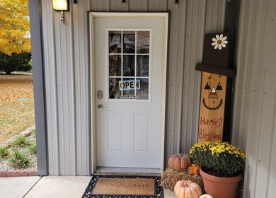 Inviting fall-themed entrance of Julia's Wellness for Her, LLC in Warsaw, Indiana, US, with decor and open sign.