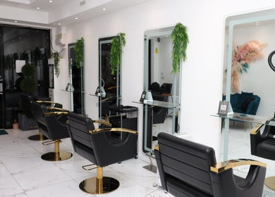 Chic interior of Dlux Beauty, London, England, GB with modern salon chairs and mirrors.