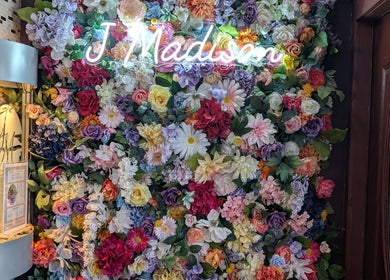 Vibrant floral wall display with J. Madison Spa neon sign in Kingston, PA, US.