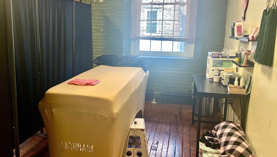 Cozy treatment room at Rosy Cheeks Beauty Studio in Biddeford, Maine, US, featuring a massage table and decor.