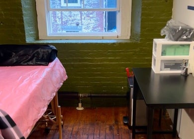 Cozy treatment room at Rosy Cheeks Beauty Studio in Biddeford, Maine, US, featuring a pink-covered bed.