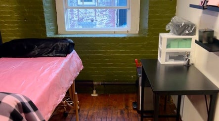 Cozy treatment room at Rosy Cheeks Beauty Studio in Biddeford, Maine, US, featuring a pink-covered bed.