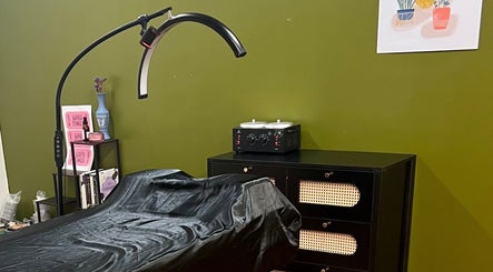Comfortable treatment space at Rosy Cheeks Beauty Studio, Biddeford, Maine, US, with a stylish green backdrop.