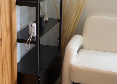 Elegant white armchair and shelf decor at Haus of BossBunnii, Orlando, Florida, US, showcasing a serene ambiance.