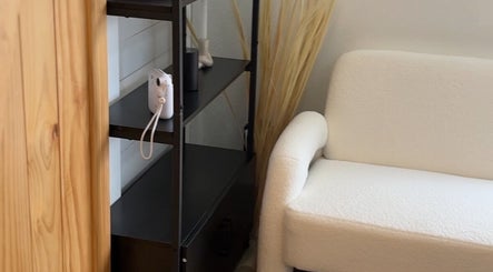 Elegant white armchair and shelf decor at Haus of BossBunnii, Orlando, Florida, US, showcasing a serene ambiance.