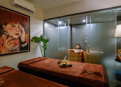 Phòng spa thư giãn tại Relax Massage & Spa Sapa, Lào Cai, Lào Cai, VN với bồn ngâm gỗ và tranh nghệ thuật.