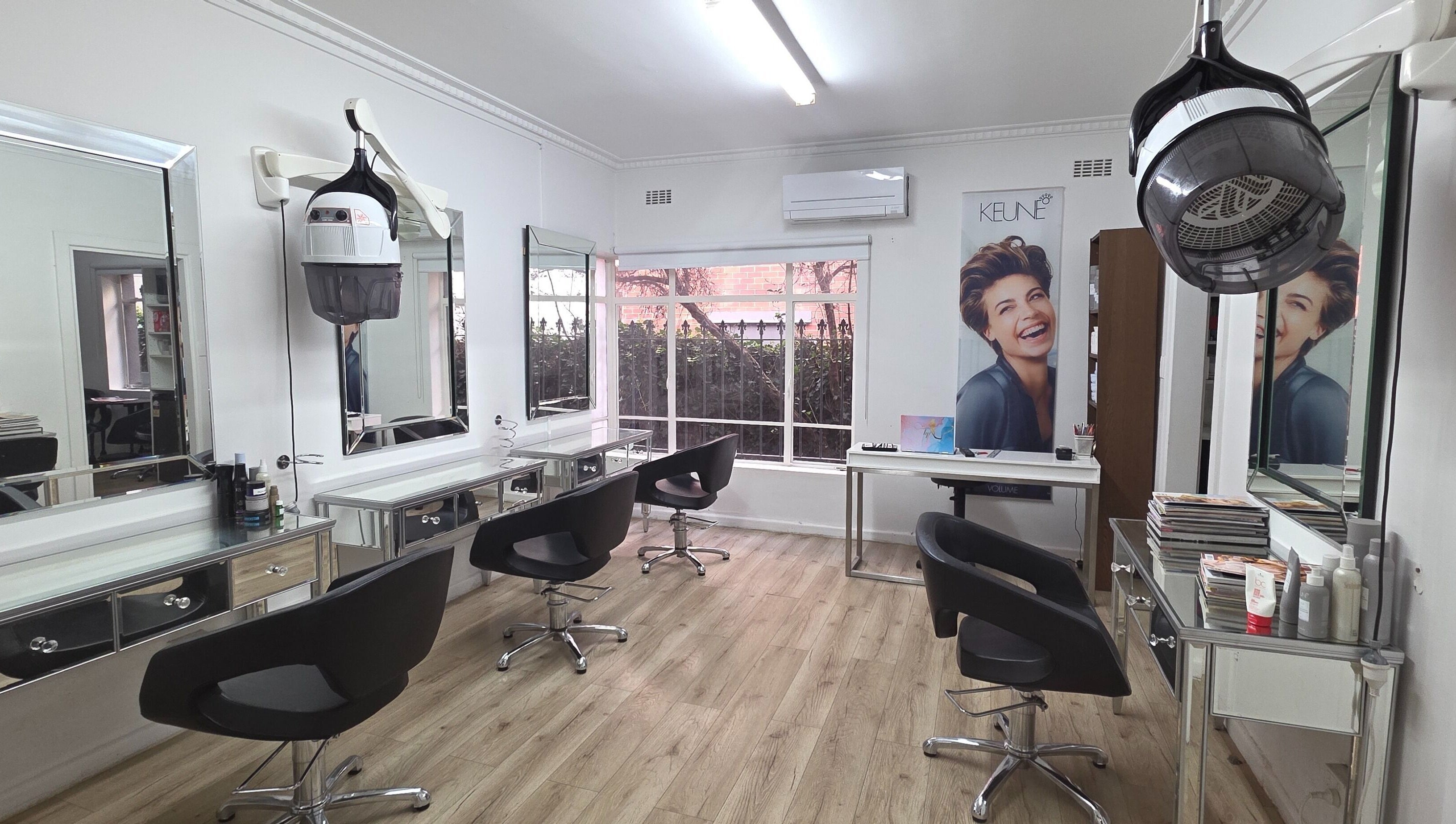 Chic interior of Madu's Creation salon in Melbourne, Victoria, AU, featuring modern styling stations and equipment.