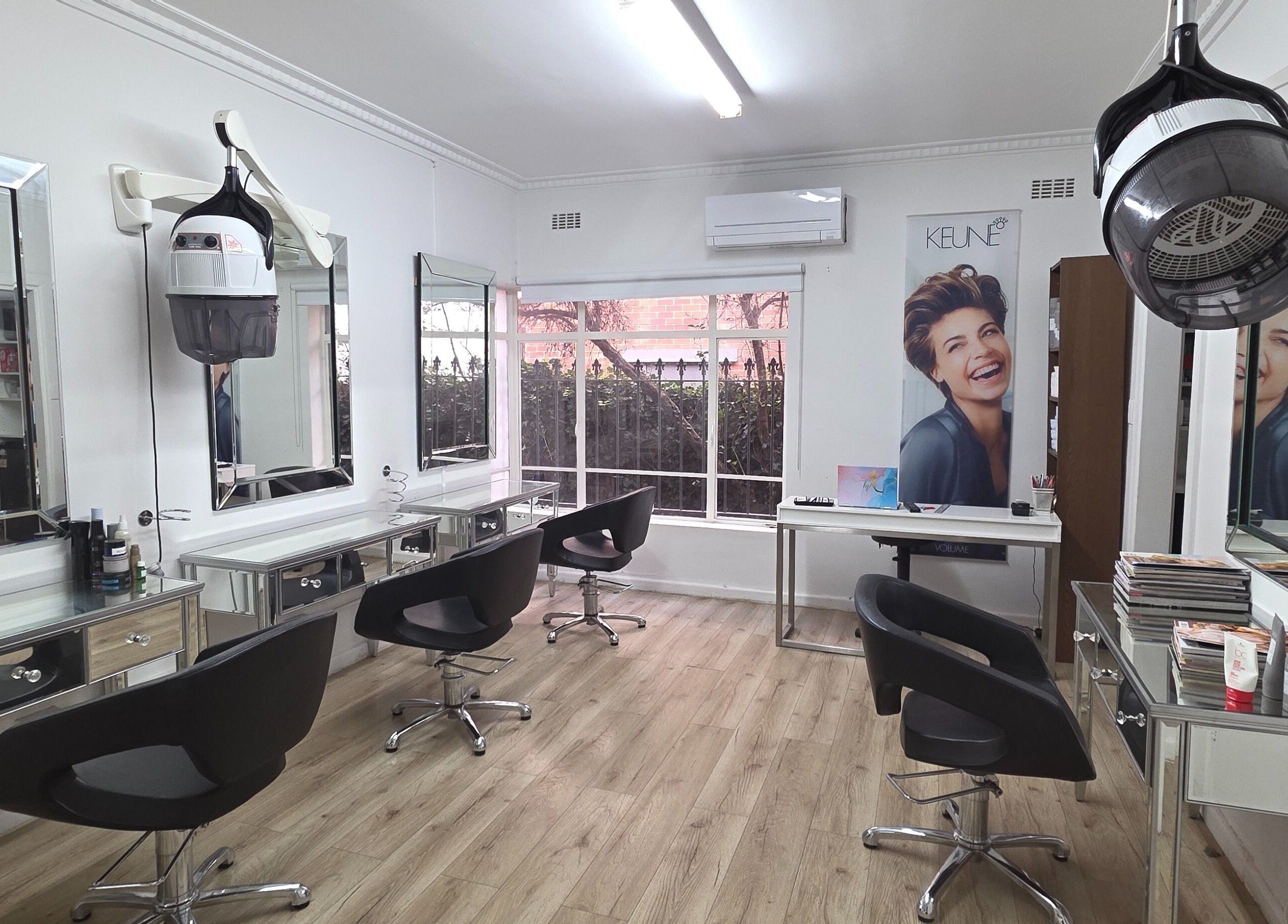 Chic interior of Madu's Creation salon in Melbourne, Victoria, AU, featuring modern styling stations and equipment.