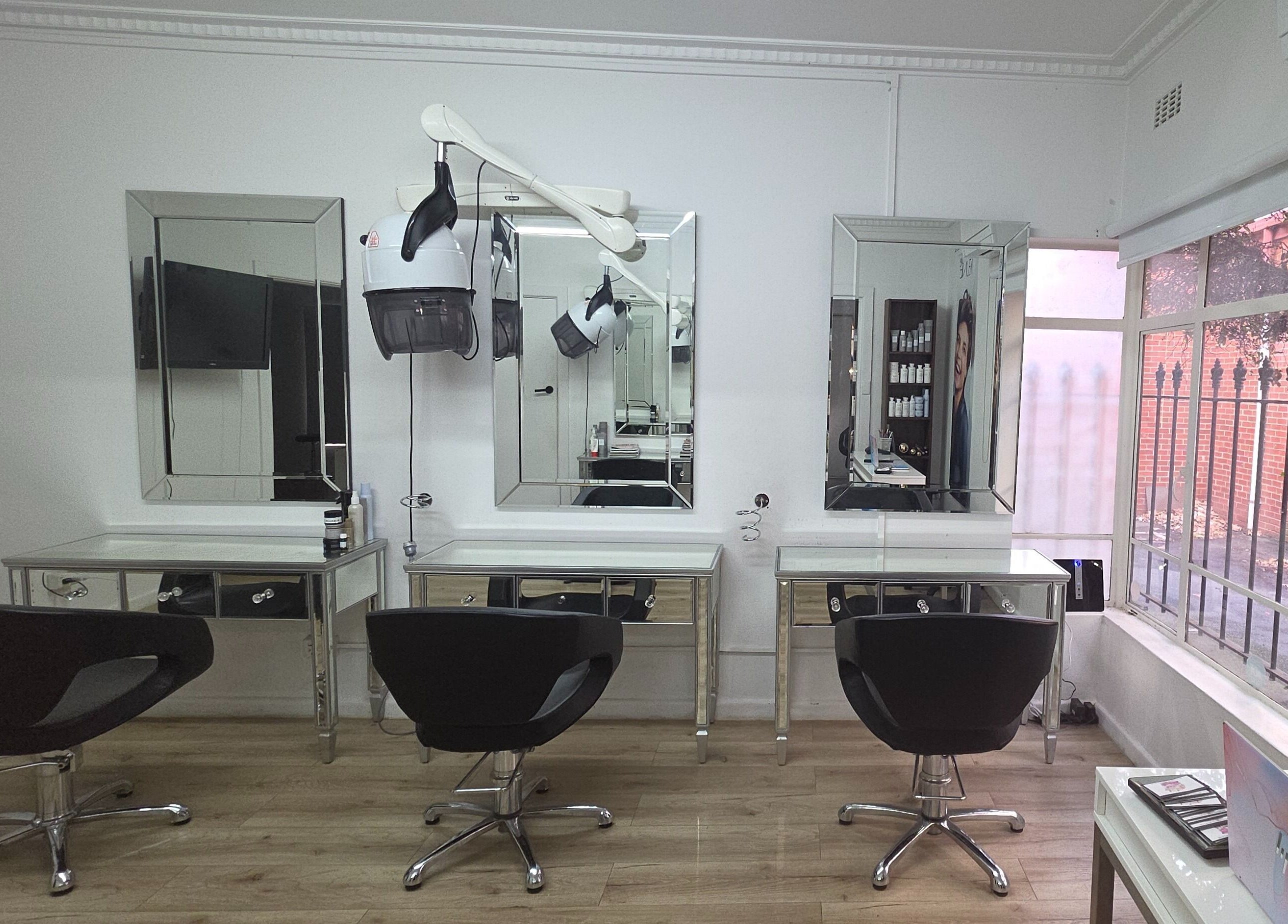 Elegant salon interior at Madu's Creation, Melbourne, Victoria, AU featuring stylish chairs and large mirrors.