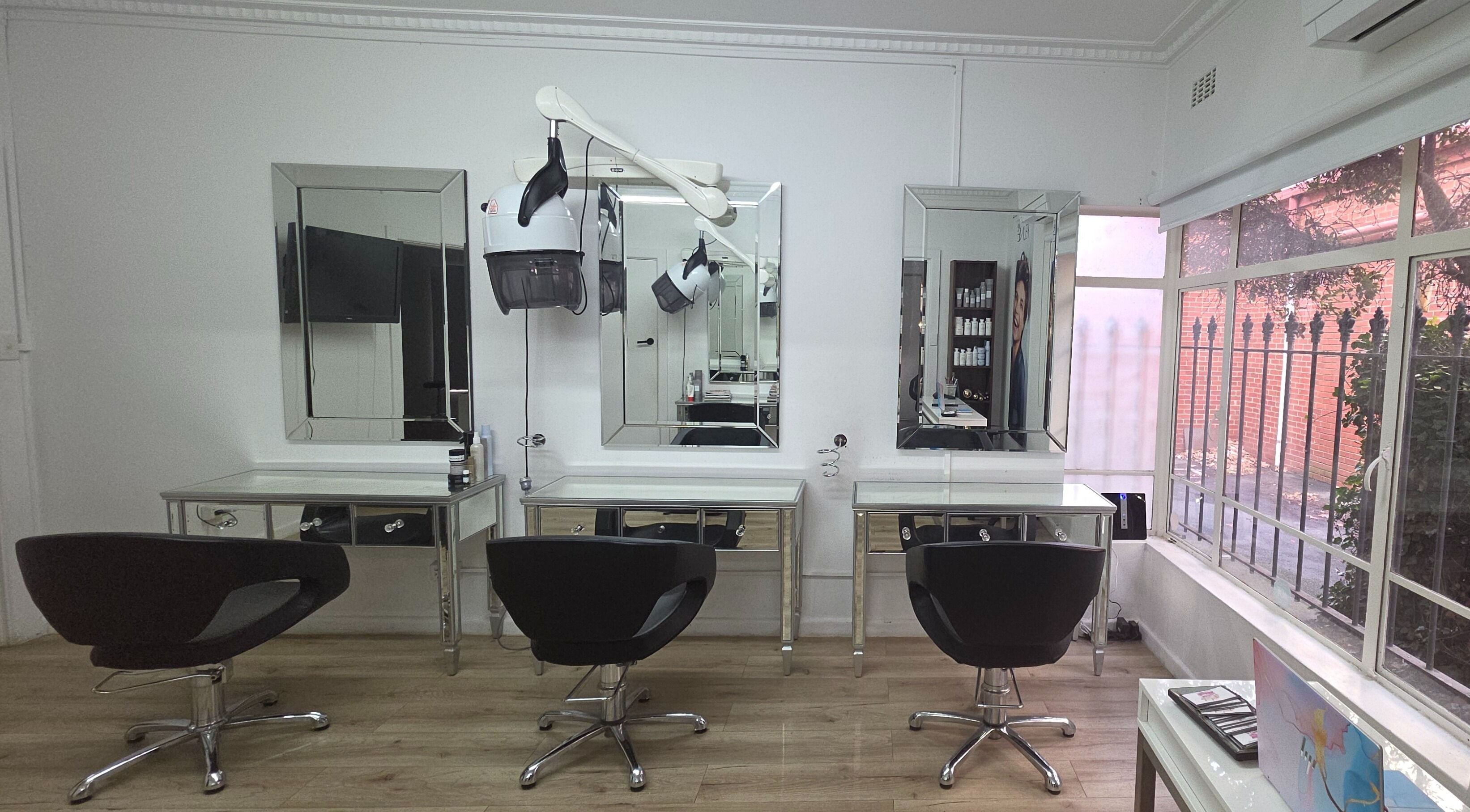 Elegant salon interior at Madu's Creation, Melbourne, Victoria, AU featuring stylish chairs and large mirrors.