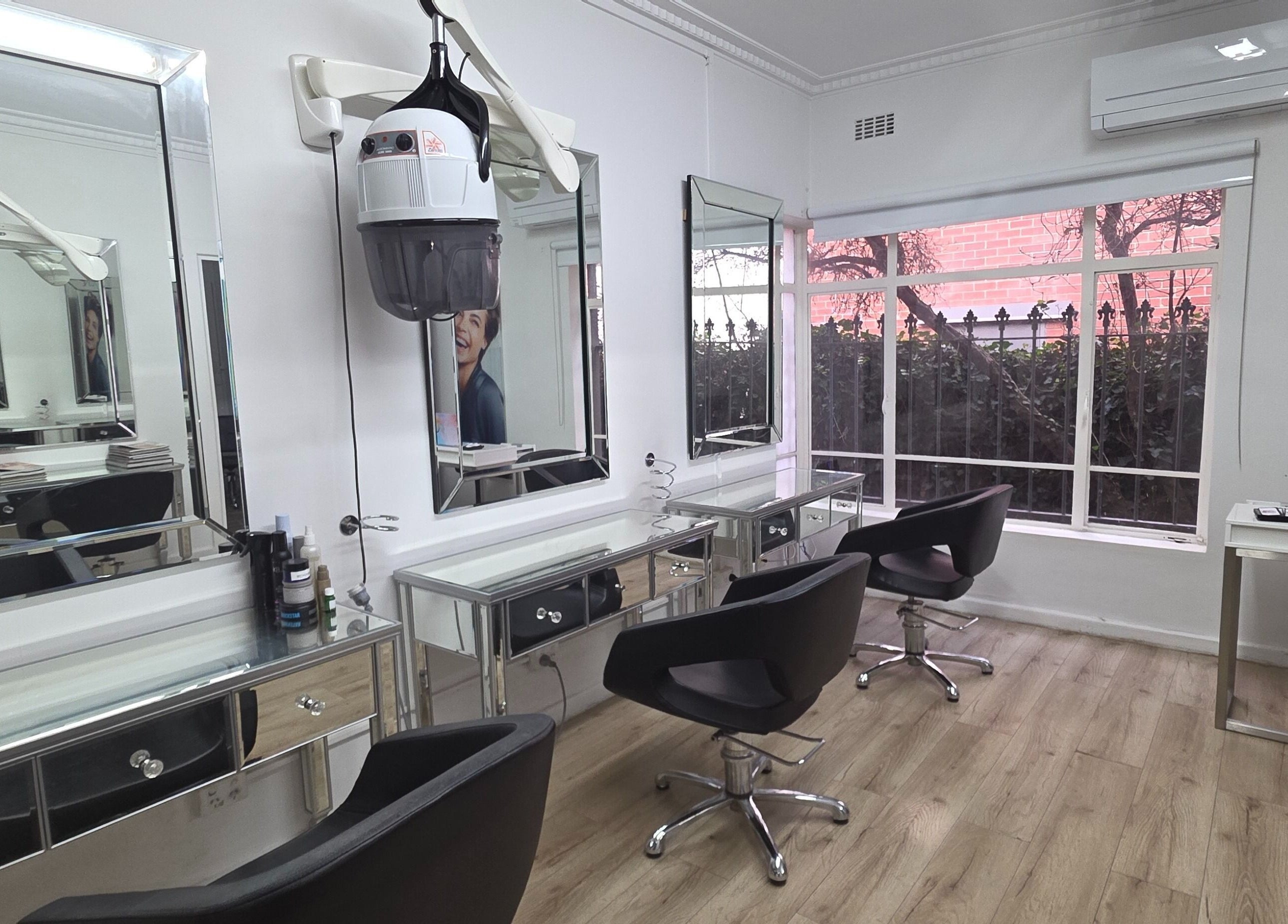 Modern salon interior at Madu's Creation, Melbourne, Victoria, AU, with styling stations and mirrors.