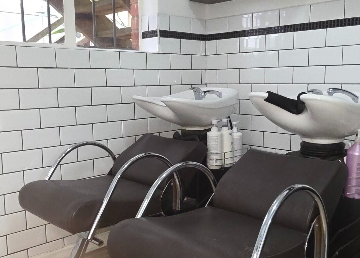 Elegant wash stations at Madu's Creation in Melbourne, Victoria, AU with tiled walls and modern chairs.
