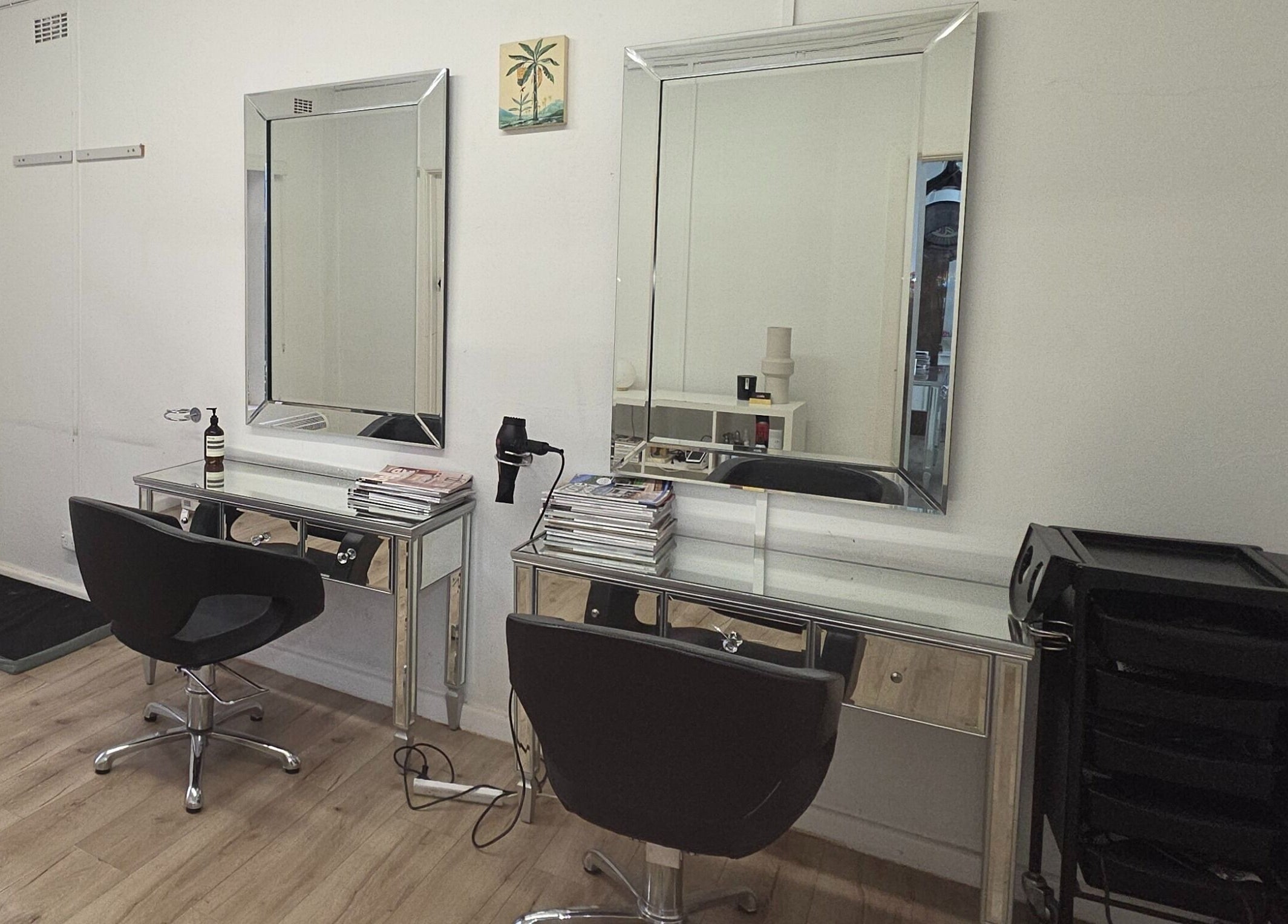 Madu's Creation salon styling station in Melbourne, Victoria, AU. Sleek mirrors and chairs create a modern look.