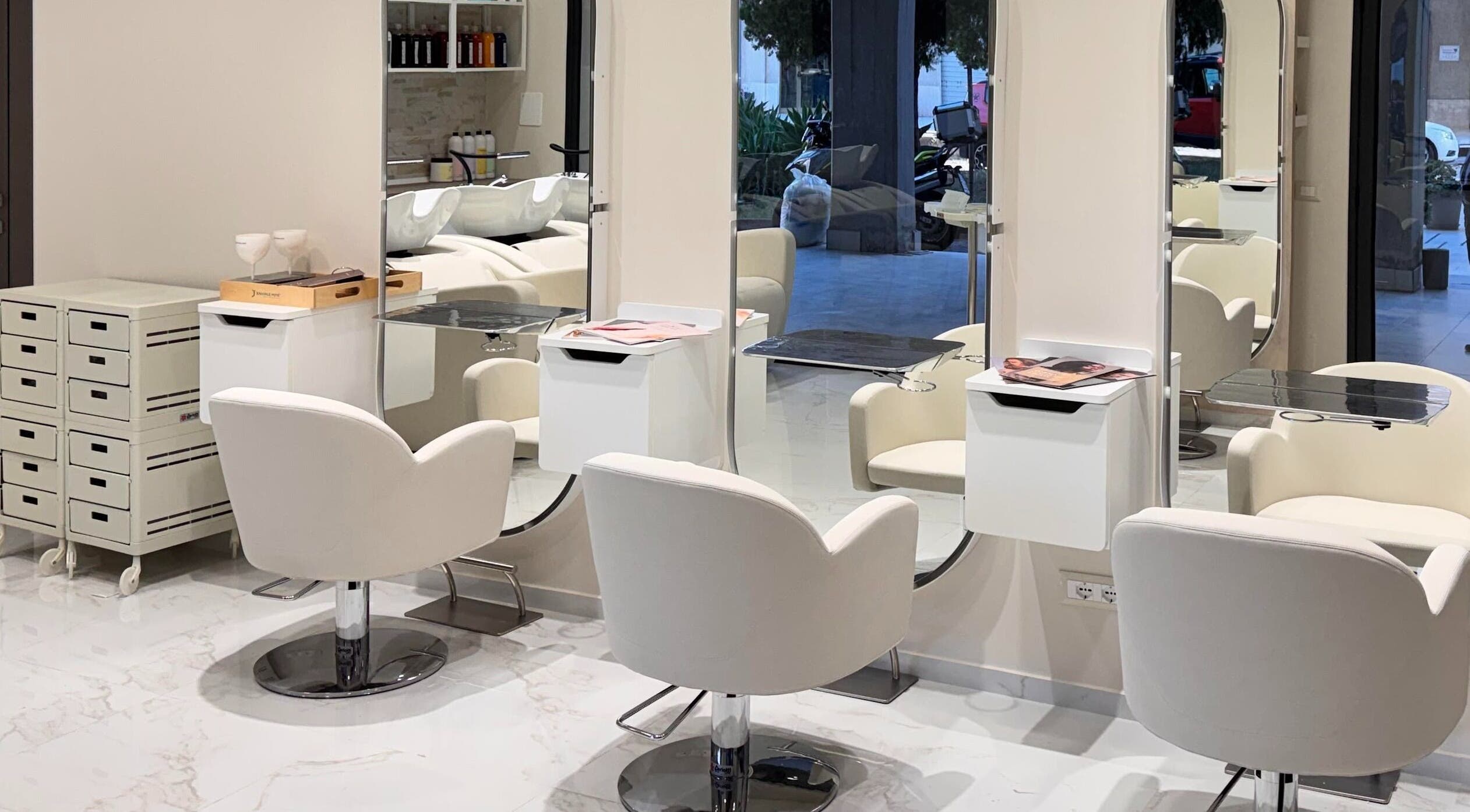 Interni eleganti di Enza Costantino Salon Beauty a Carlentini Nord, Sicilia, IT con sedie bianche e specchi moderni.