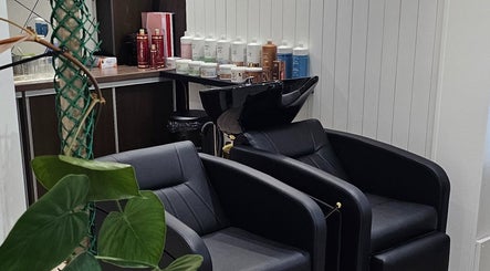 Intérieur de Studio 9 à La Possession, La Réunion avec fauteuils noirs et produits capillaires.