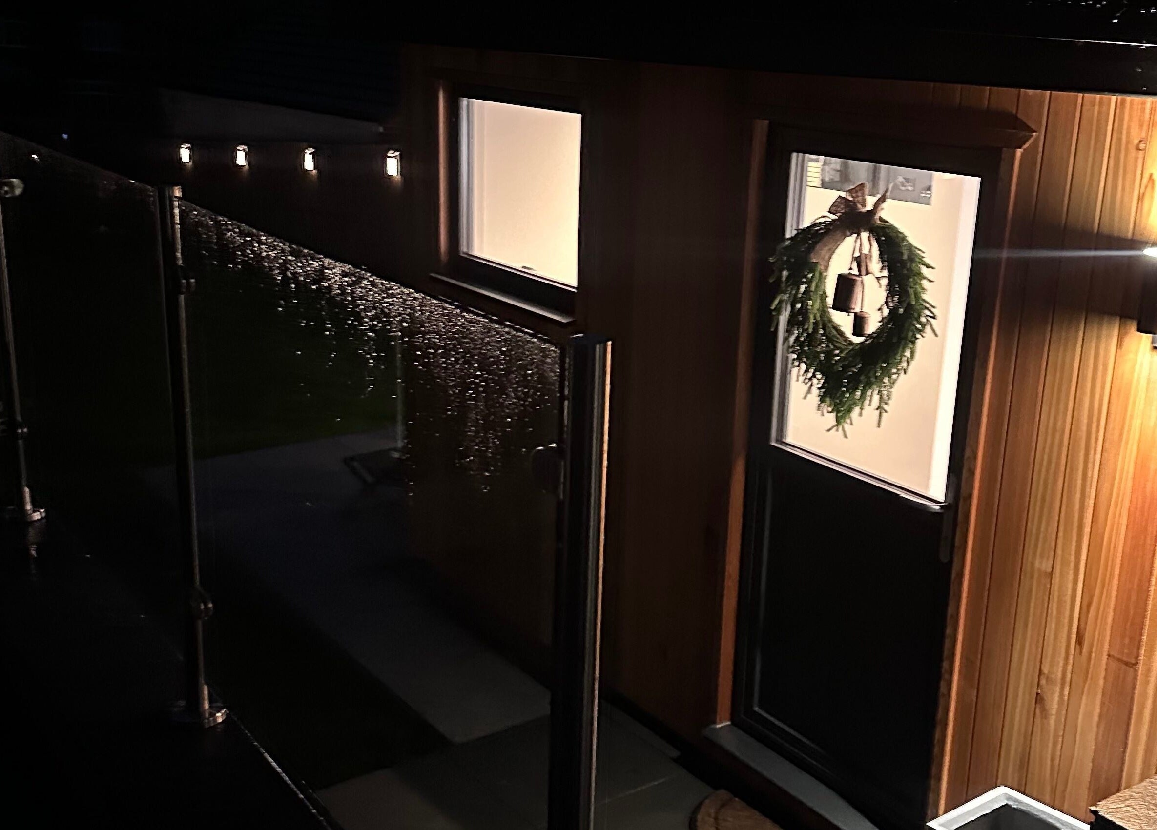 Night view of SKN Lab Yorkshire's entrance in Wakefield, England with decorative wreath and soft lighting.